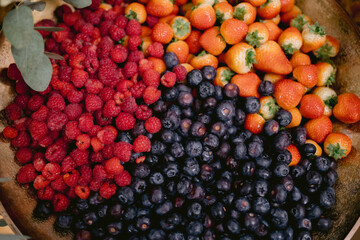 several fruits in a metal bowl on the counter top of the table