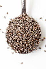 Chia seeds in iron spoon on white background. Close-up