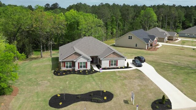 Drone of New residential home in a ranch, and parked cars, with trees in the background