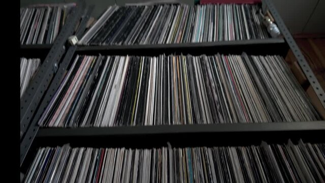 Low angle Interior shot of many old audio vinyl records on industrial shelves in a dusty basement