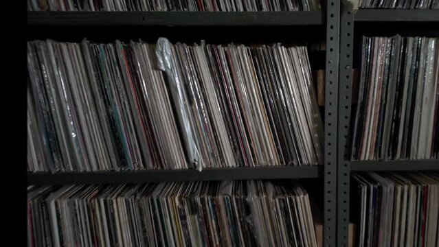 Closeup Interior shot of many old audio vinyl records on industrial shelves in a dusty basement