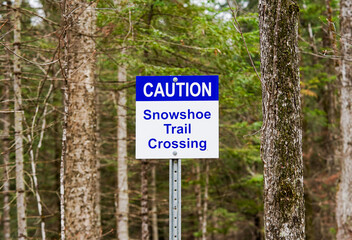 And white caution sign in forest during low tide