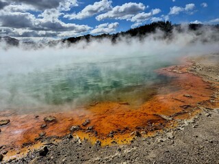 the thermal in the middle of a body of water with colorful clouds in the background
