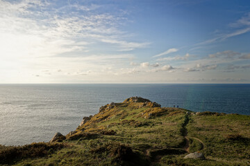 People standing on a mountain peak overlooking the ocean