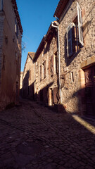 European village alley with stone buildings in Cordes sur Ciel town, France