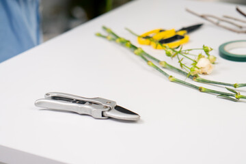 close-up in flower shop on a white table there are pruning shears for cutting flowers
