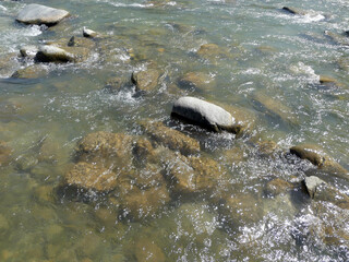 Crystal clear flowing water and stones in the river