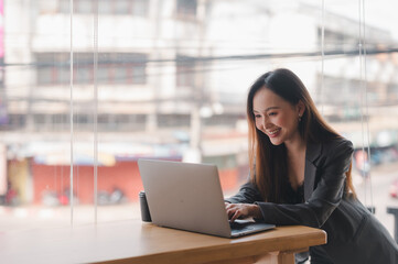 business woman wearing suit drinking coffee using laptop in cafe.