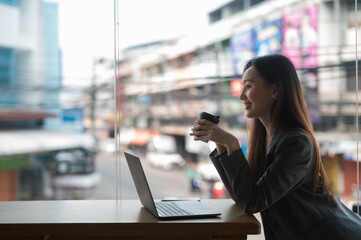 business woman wearing suit drinking coffee using laptop in cafe.