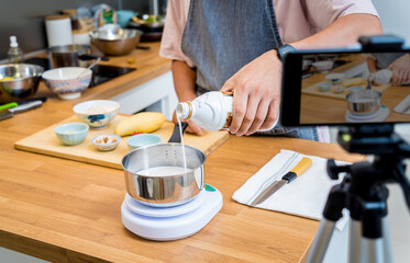 Chef at the kitchen preparing bowl of oats with strawberries and mango