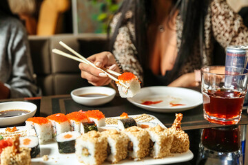 Woman Eating Sushi With Chopsticks at a Restaurant