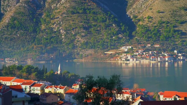 View of Prcanj town as seen from Dobrota town on the Bay of Kotor on a sunny day, Montenegro