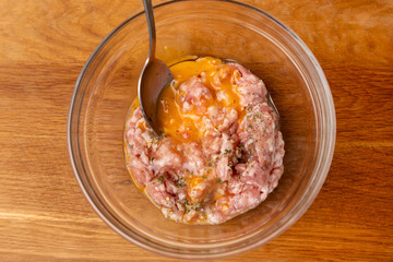 An egg and greens are added to the minced meat. Minced meat for cooking fried meat cutlets.