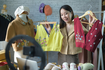Fashion blogger concept, women selling clothes on video streaming.Startup small business SME, using smartphone or tablet