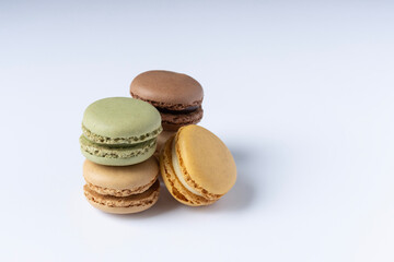 Macarons on a white background close-up. Orange green and brown macaroons. Space for text