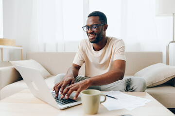 Smiling African American Man Freelancer Working on Laptop in Modern Home Office