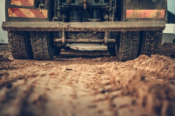 Closeup shot of a truck working on the field all covered in mud