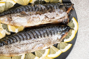 Oven-baked mackerel sea fish dish served with fresh lemon slices