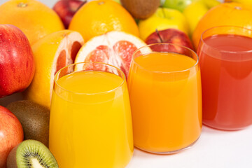 Different fruit juices in glasses on white background