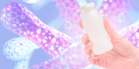 Bottle with probiotics in hand. Lactobacillus cells. Packaging for yogurt with probiotics. Healthy...