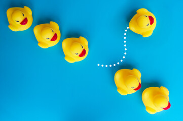 Top view of rubber duck one leaving the others. Leader and followers concept.