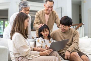 Father and mother with asian kid girl learn on laptop computer reviewing lesson study with online education e-learning.student look for educational knowledge in homeschool at home.Education