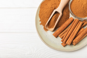 Cinnamon sticks on a textured wooden background. Cinnamon roll. Spicy spice for baking, desserts and drinks. Fragrant ground cinnamon. cinnamon powder Close-up. Place for text. copy space