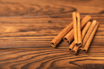 Cinnamon sticks on a textured wooden background. Cinnamon roll. Spicy spice for baking, desserts and drinks. Fragrant ground cinnamon. cinnamon powder Close-up. Place for text. copy space