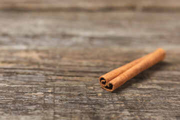 Cinnamon sticks on a textured wooden background. Cinnamon roll. Spicy spice for baking, desserts and drinks. Fragrant ground cinnamon. cinnamon powder Close-up. Place for text. copy space