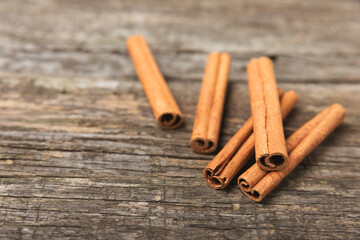 Cinnamon sticks on a textured wooden background. Cinnamon roll. Spicy spice for baking, desserts and drinks. Fragrant ground cinnamon. cinnamon powder Close-up. Place for text. copy space