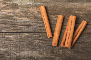 Cinnamon sticks on a textured wooden background. Cinnamon roll. Spicy spice for baking, desserts and drinks. Fragrant ground cinnamon. cinnamon powder Close-up. Place for text. copy space