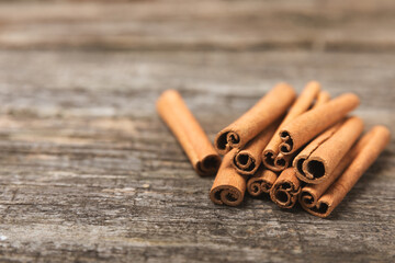 Cinnamon sticks on a textured wooden background. Cinnamon roll. Spicy spice for baking, desserts and drinks. Fragrant ground cinnamon. cinnamon powder Close-up. Place for text. copy space