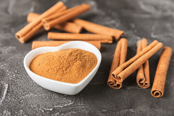 Cinnamon sticks on a textured wooden background. Cinnamon roll. Spicy spice for baking, desserts and drinks. Fragrant ground cinnamon. cinnamon powder Close-up. Place for text. copy space