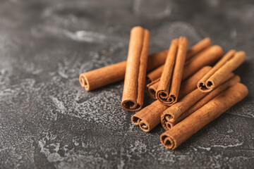 Cinnamon sticks on a textured wooden background. Cinnamon roll. Spicy spice for baking, desserts and drinks. Fragrant ground cinnamon. cinnamon powder Close-up. Place for text. copy space