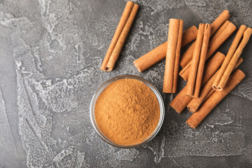 Cinnamon sticks on a textured wooden background. Cinnamon roll. Spicy spice for baking, desserts and drinks. Fragrant ground cinnamon. cinnamon powder Close-up. Place for text. copy space