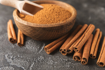 Cinnamon sticks on a textured wooden background. Cinnamon roll. Spicy spice for baking, desserts and drinks. Fragrant ground cinnamon. cinnamon powder Close-up. Place for text. copy space