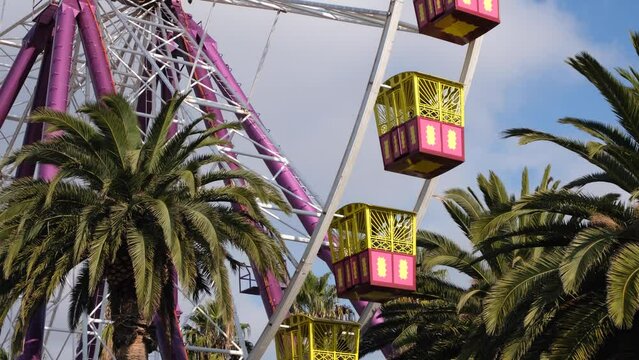A Ferris wheel's carriage moves and spinning with trees surrounding it. Concept of a happy, nostalgic atmosphere in amusement parks or fairs. Geelong VIC Australia