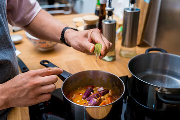 Chef at the kitchen preparing massaman curry with sweet potato and many spices