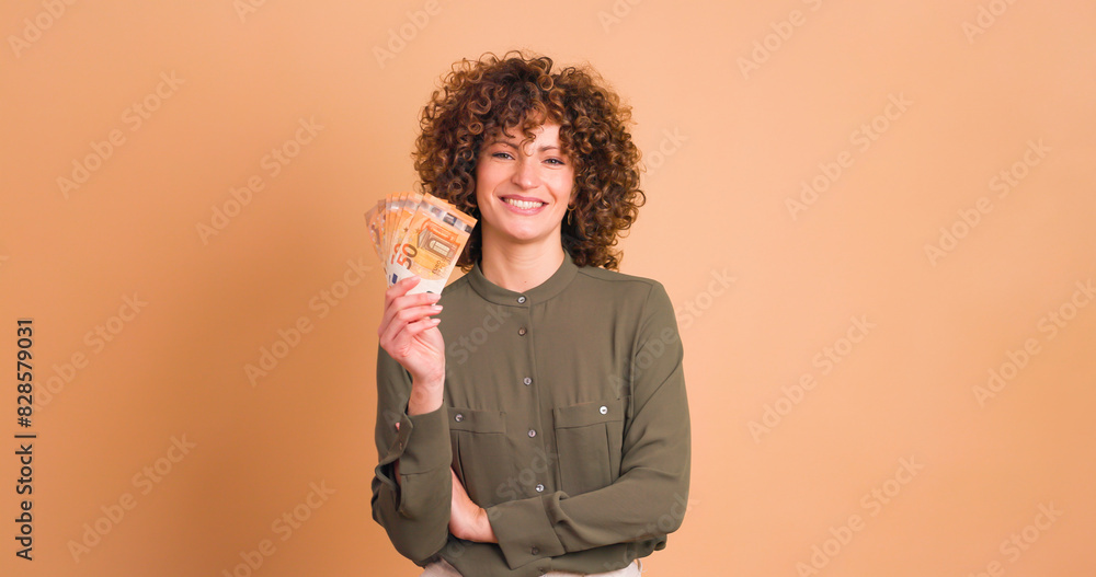 Wall mural Woman showing Euro banknotes in beige studio