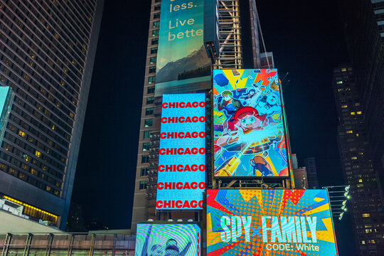 Nighttime view of Times Square with LED billboards on skyscraper facades showcasing Broadway musical Chicago. New York. USA.