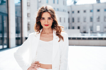 Young beautiful brunette woman wearing nice trendy white suit jacket. Sexy smiling model posing in...