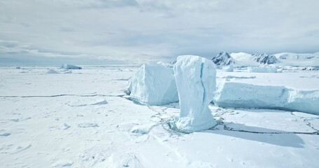 Towering icebergs from cracked glacier stuck in frozen polar ocean. Untouched wild beauty Antarctica nature landscape. Winter scene. Desert snow covered white land and ice. Aerial drone panorama © mozgova