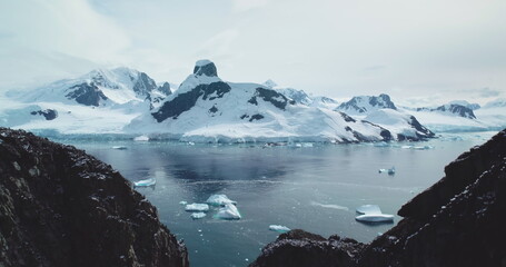 Snow-covered mountains stunning arctic landscape. Melting icebergs from crashed glacier floating...