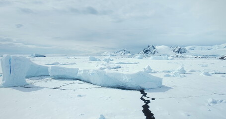 Colossal iceberg from crashed glacier towering in frozen ocean. Desert white land of snow and ice....