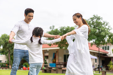 Fototapeta premium Portrait of enjoy happy love asian family father and mother holding hug cute little asian girl child smiling play and having fun moments good time, care, kid, support, insurance, child, at home