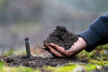 Holding soil in a hand, feeling compost in a field in Tasmania Australia.