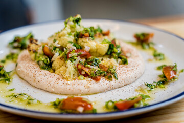 Tasty bean porridge with cauliflower and vegetables on white plate