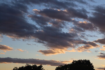 scattered clouds dark below and white above at sunset