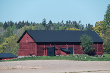 Rural scene of a nordic farm house and a field during the spring time.