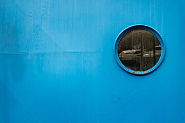 Circular porthole on the blue ship side